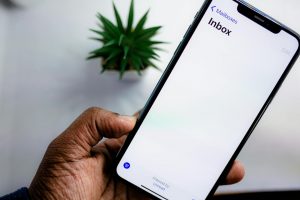 En person håller en smartphone som visar en tom inkorg filtrerad på olästa mejl.