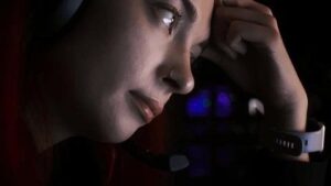 Trött person lutar huvudet mot handen framför en datorskärm